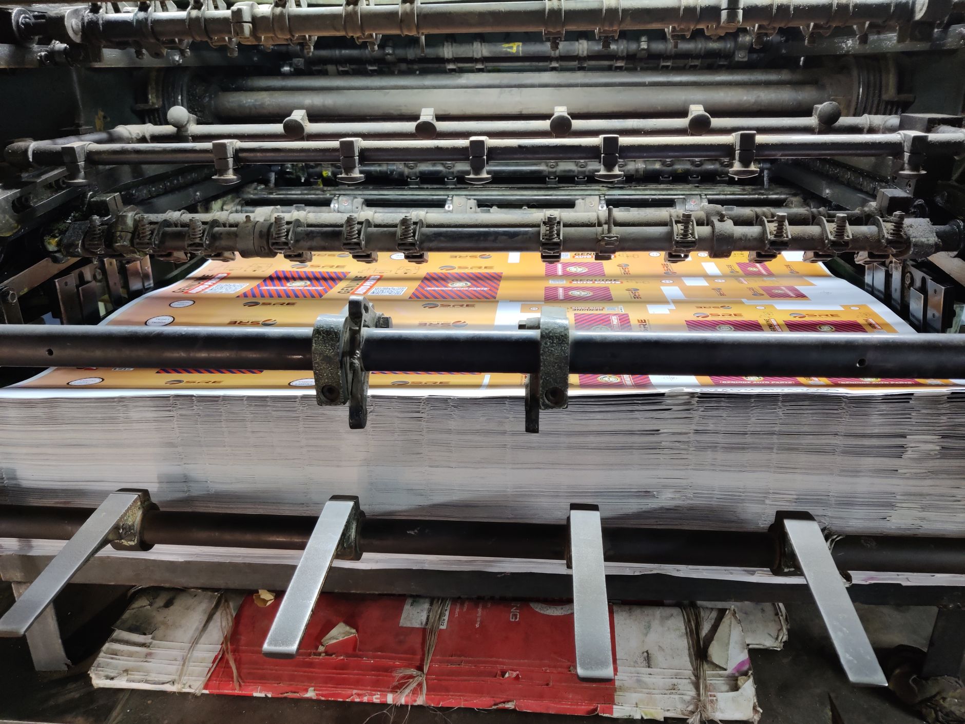 Colorful sheets running through an offset printing press